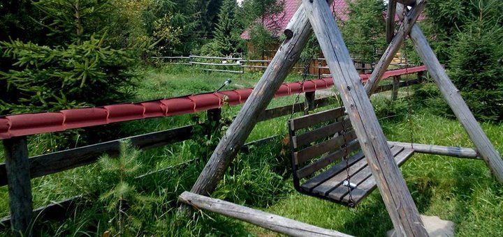 Дерев'яний гойдалки у дворі садиби «Урочище Багончик» у Ворохті. Бронюйте номери в міні-готелі за акцією.