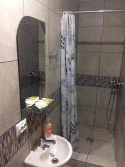 A bathroom with a shower in a standard room at the Central Park Hotel in Lviv. Register for a discount.